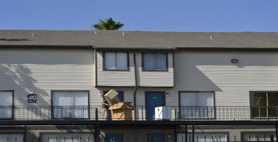 Man moving boxes in front of house