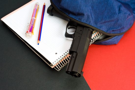 a firearm on the backpack of a young man at school